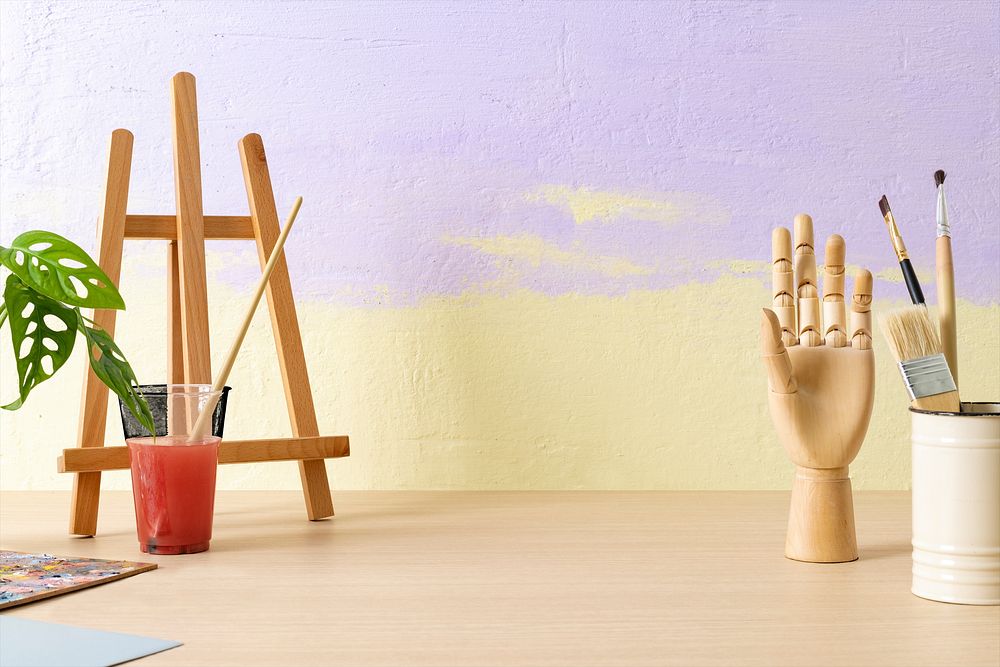 Aesthetic artist background, small easel and wooden hand mannequin, drawing class decoration