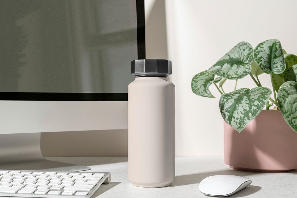 Pink thermal bottle, minimal product in aesthetic workspace