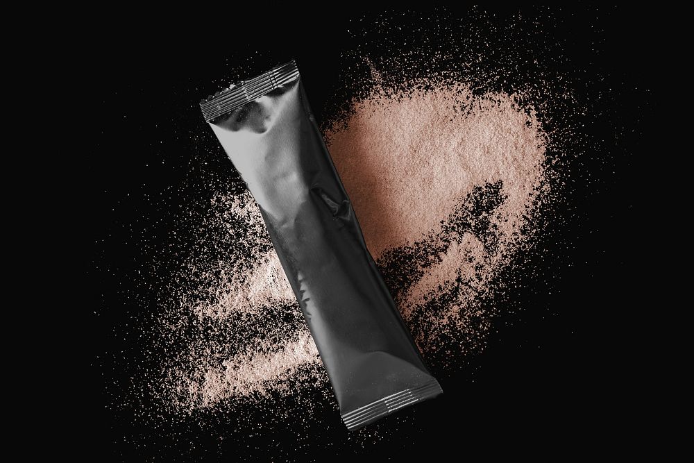 Blank black stick sachet, brown powder on black background product packaging design