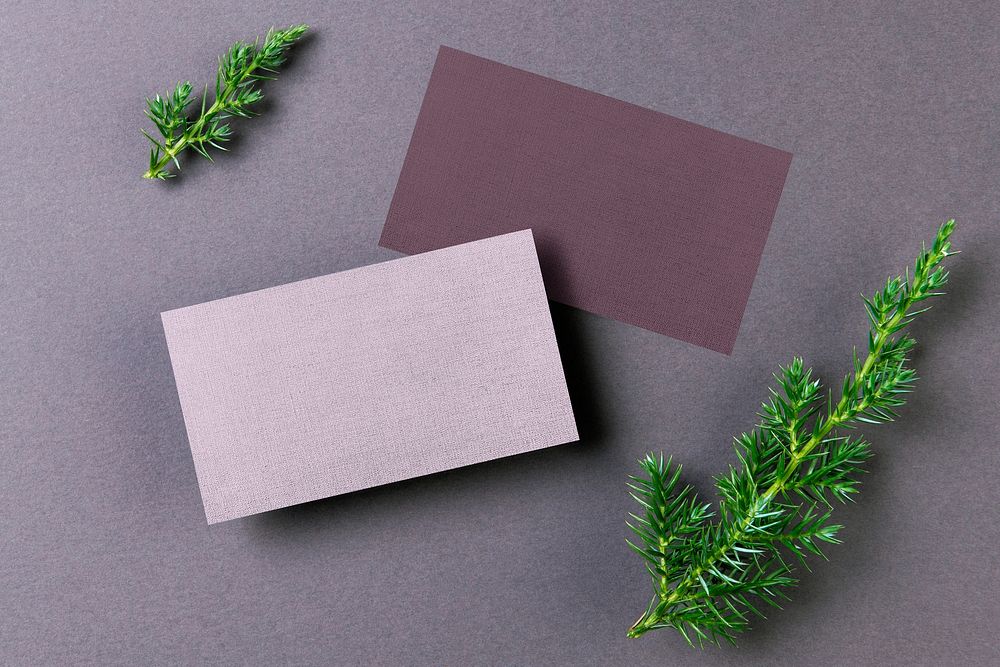 Blank purple business cards, flat lay with leaf design