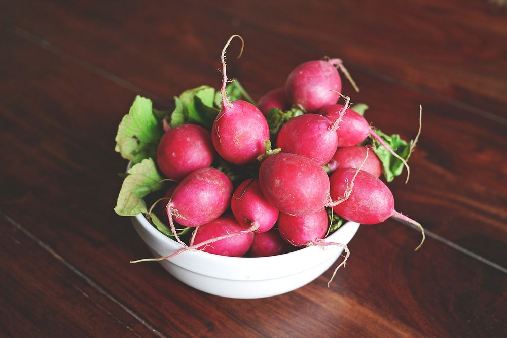 Free image of red radish in a bowl on a wooden table, public domain CC0 photo.