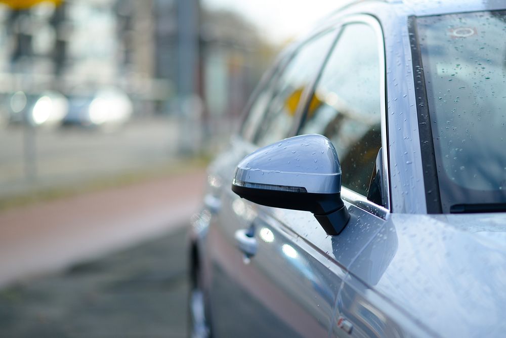 Parked car front part in blurred background photo, free public domain CC0 image.