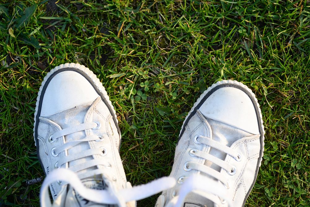 Free white sneakers on grass photo, public domain shoes CC0 image.