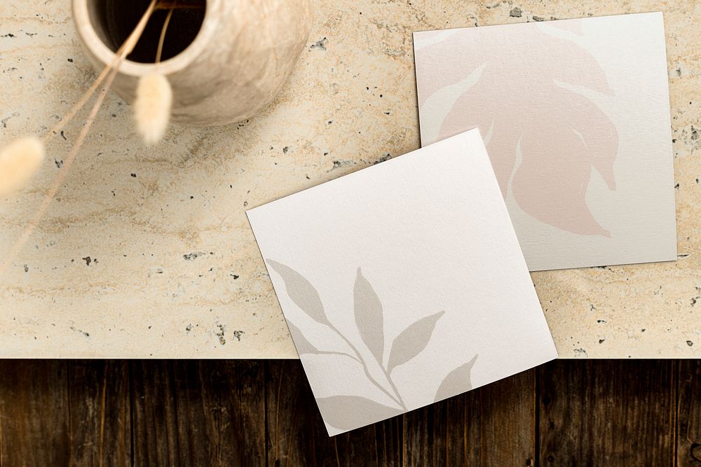 Brown table background with two square business cards flat lay
