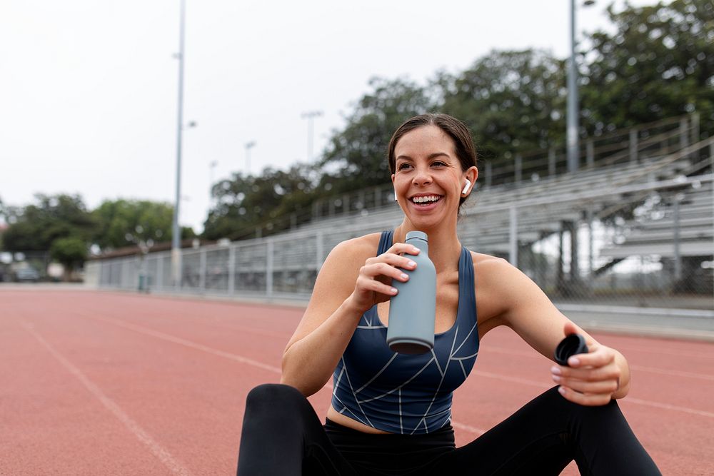 Happy woman athlete drinking water and rest 