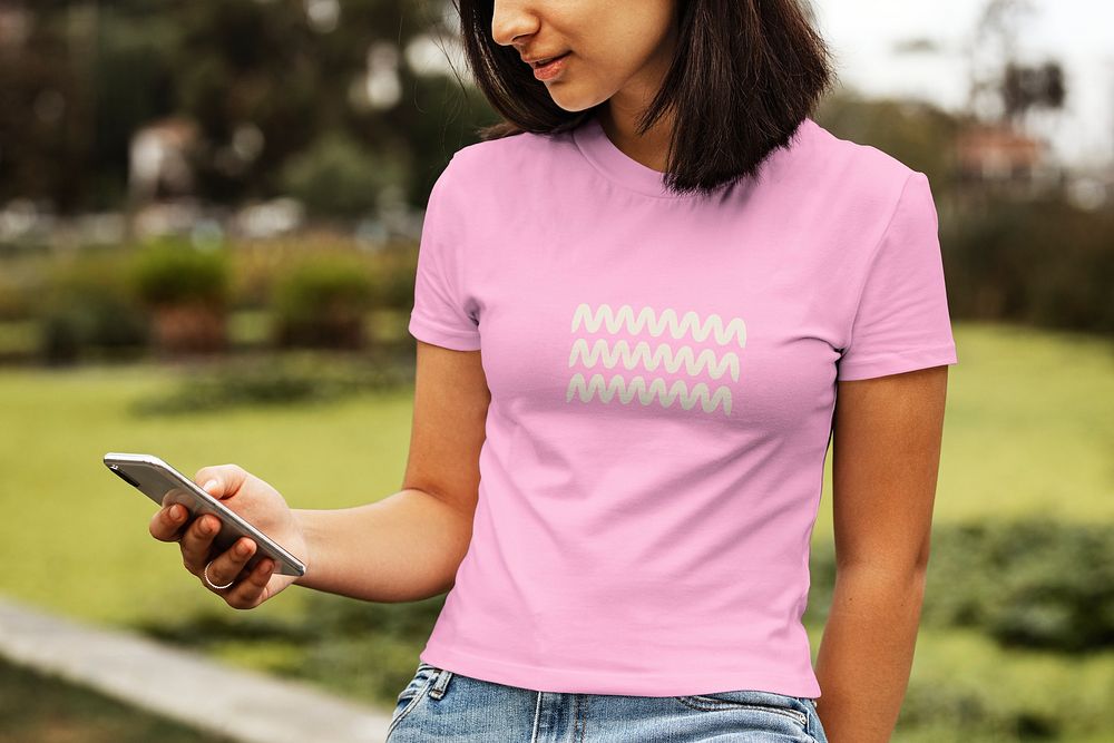 Woman texting on a phone in a park, casual wear