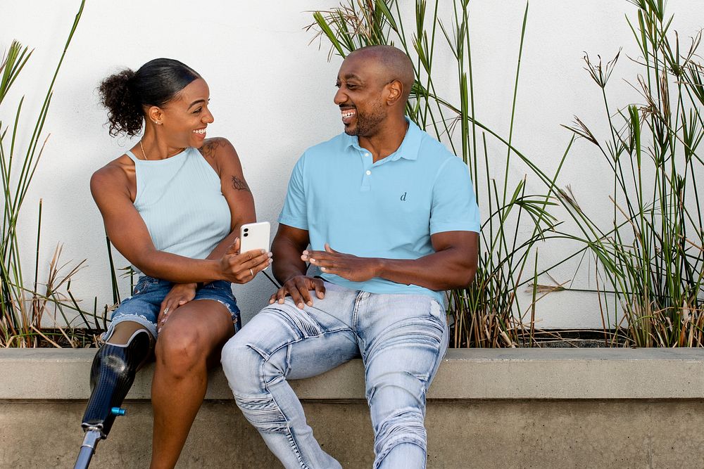 Woman showing smartphone, African American couple hanging out