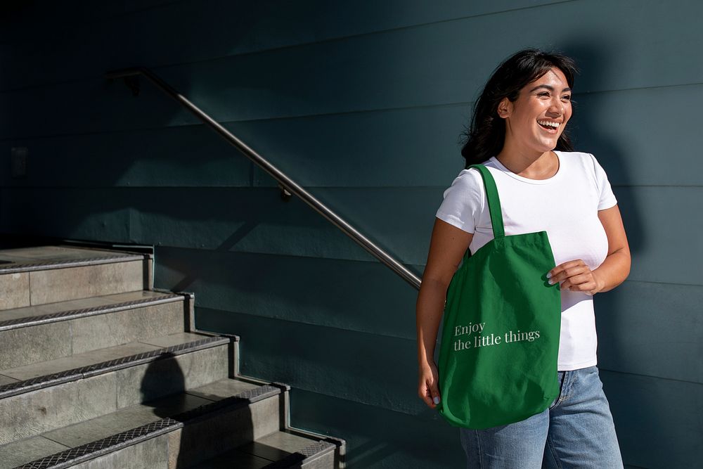 Latina woman with a green tote bag, standing by the staircase