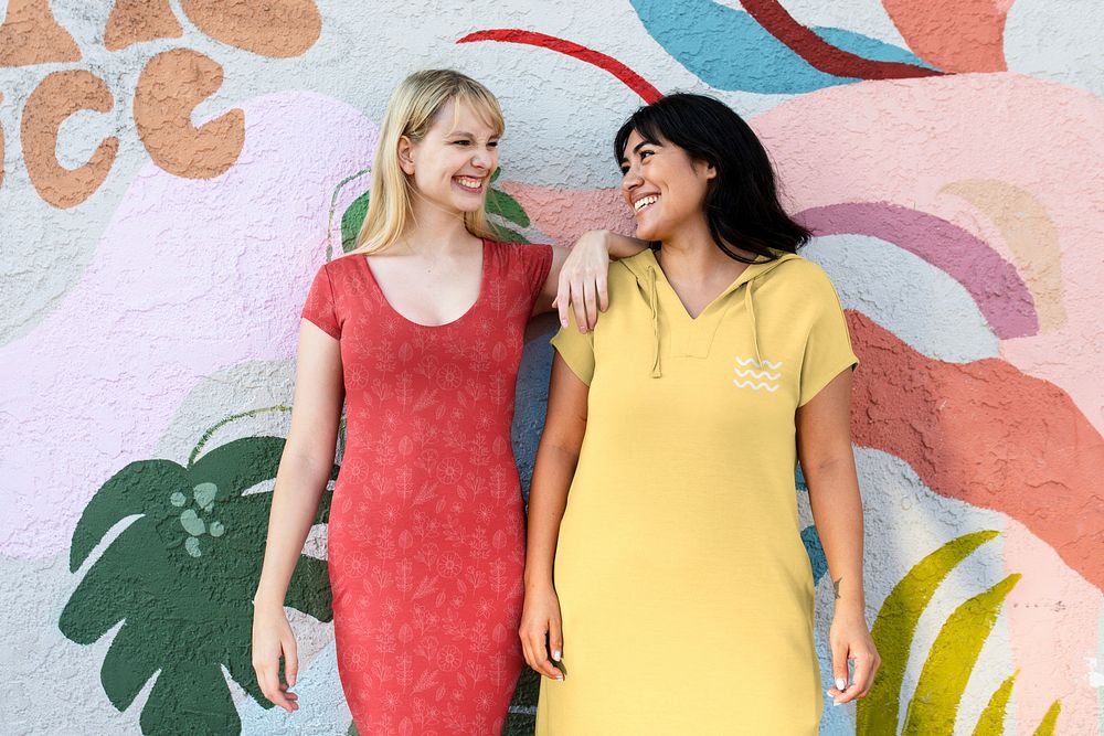 Girls wearing a dress standing by the bright summer graffiti wall