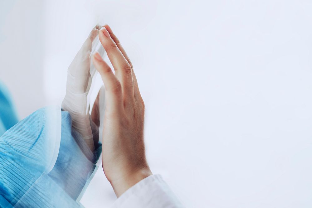 Coronavirus doctor touching family hand through a glass window