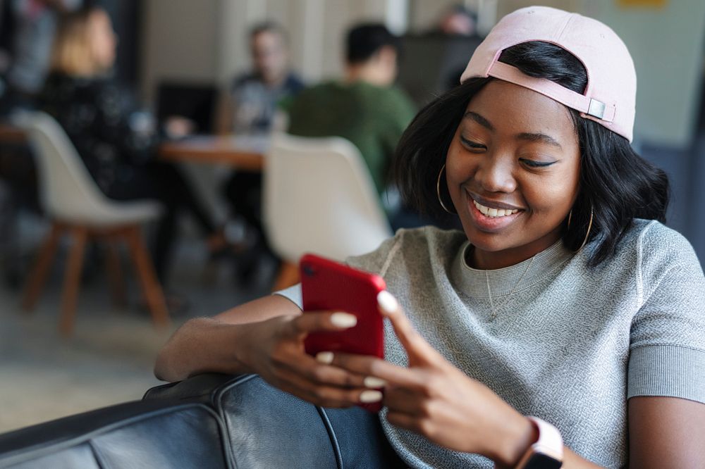 Cheerful black woman texting to her friend