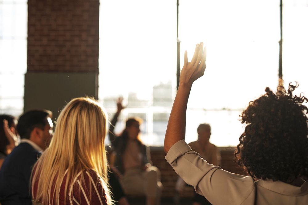 People raised their hand in a meeting