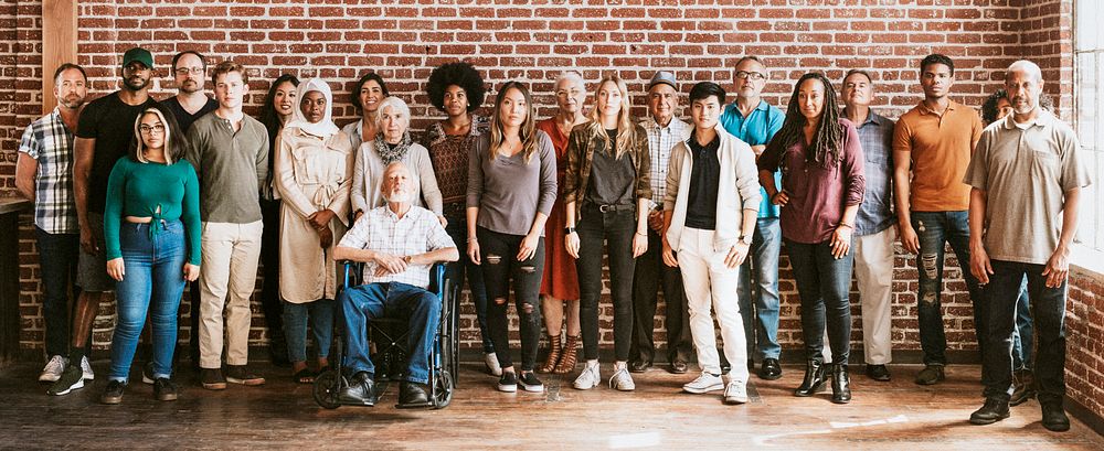 Group of diverse people standing in front of a brick wall