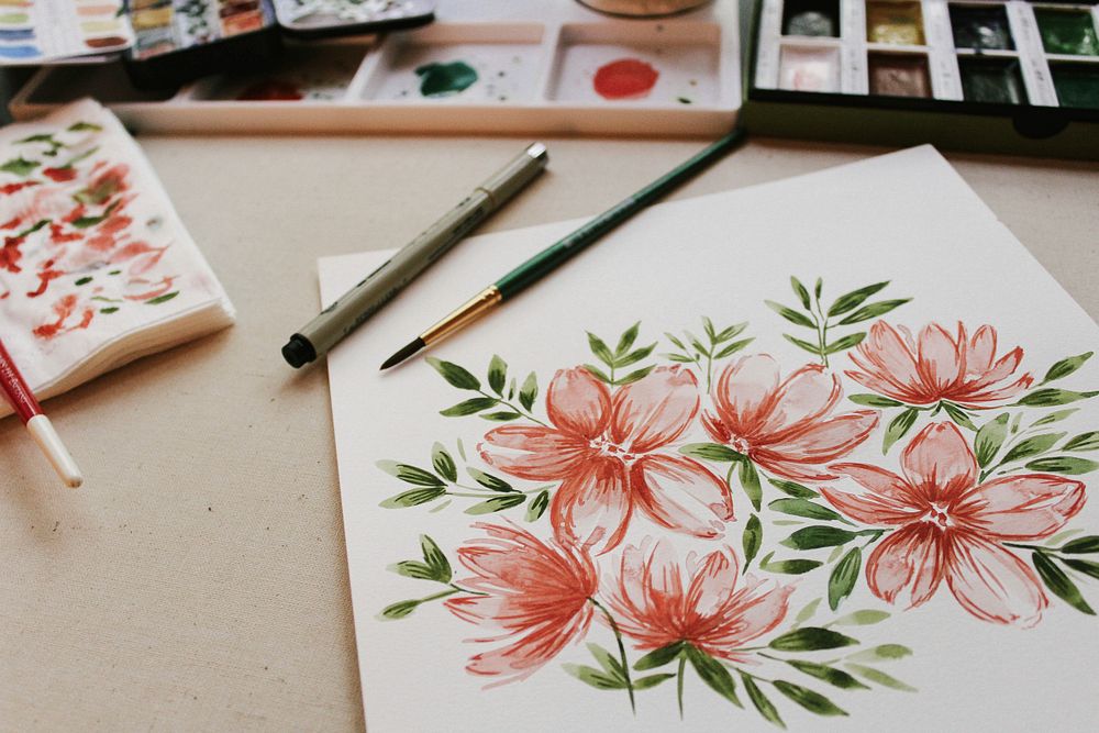Watercolour illustration of pink flowers on paper on artist's with paintbrushes and pallet, Weeki Wachee. Original public…