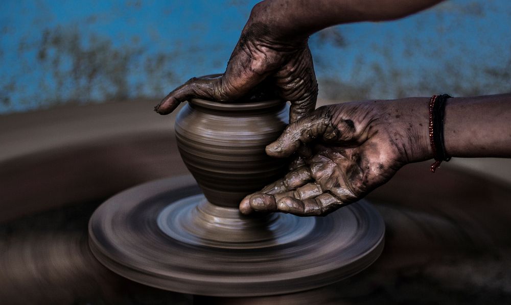Hands create art on a pottery wheel. Original public domain image from Wikimedia Commons