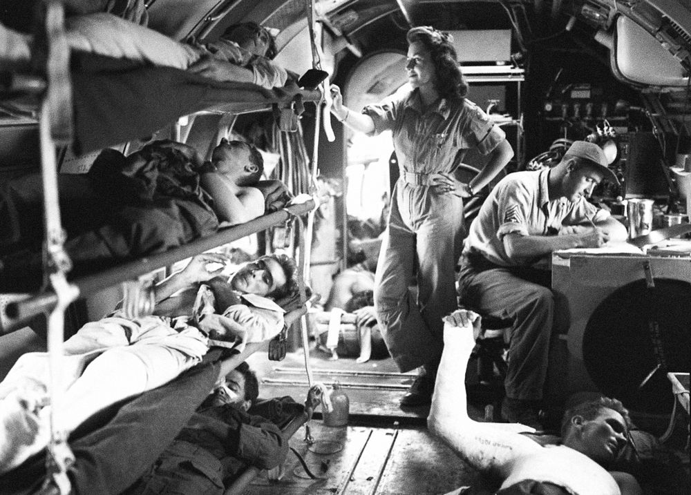 C&ndash;46 air evacuation during World War II from Manila, Philippine Islands. Patients in bunks in a plane. Nurse in…