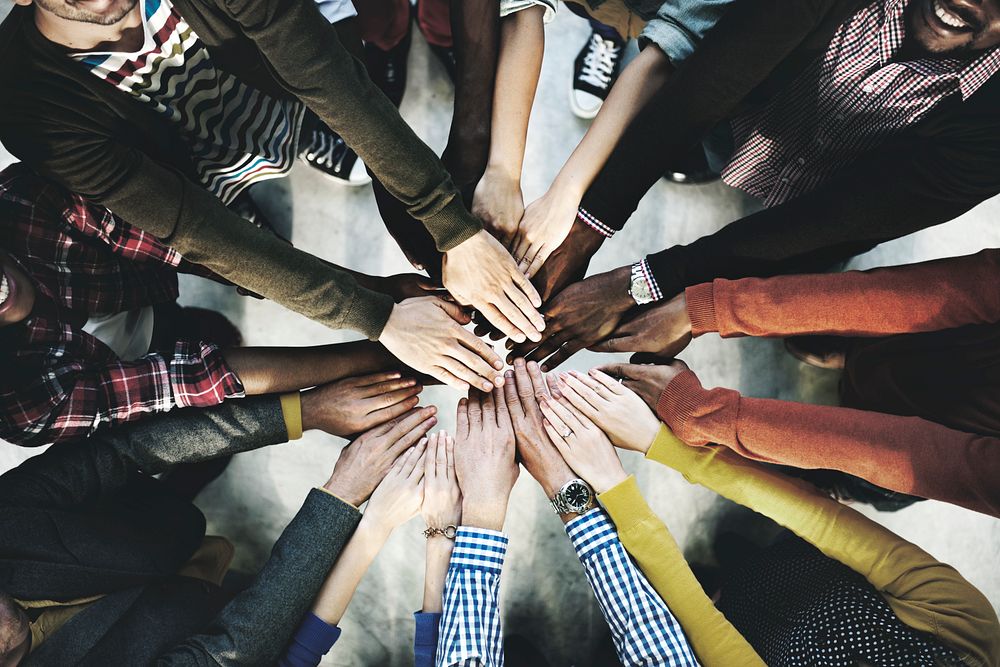 Aerial view of diverse people stacking hands in the middle
