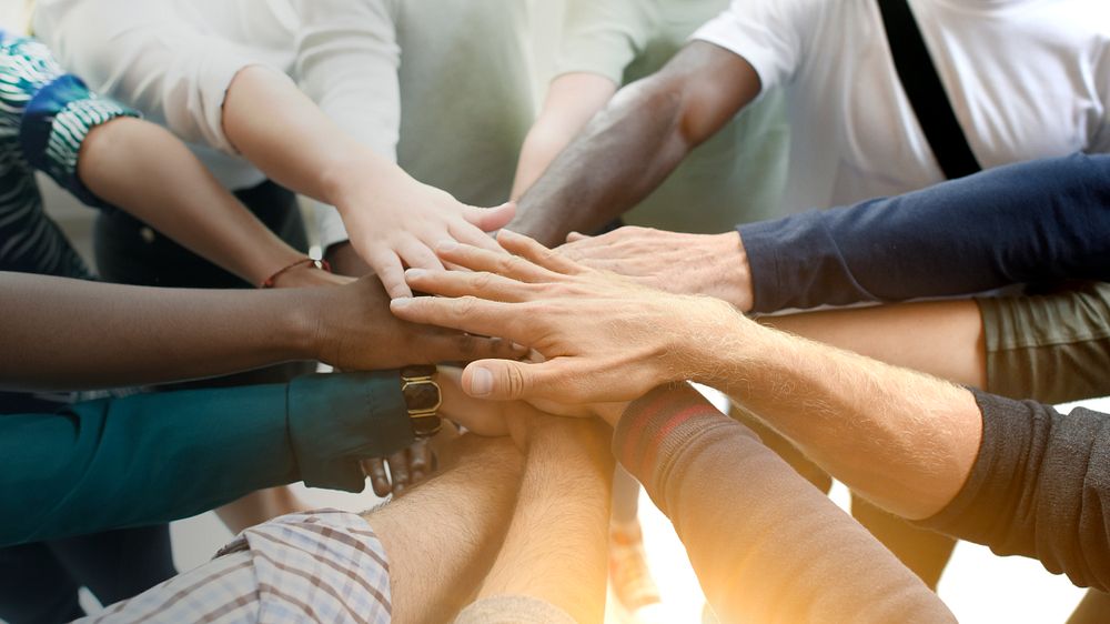 Diverse team joining their hands