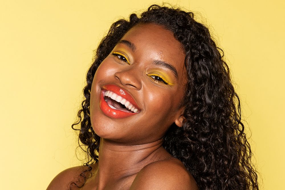 Happy black woman wearing yellow eye shadow 
