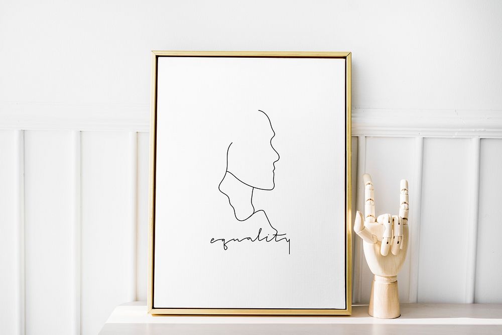 Gold photo frame by the hand mannequin on a white table