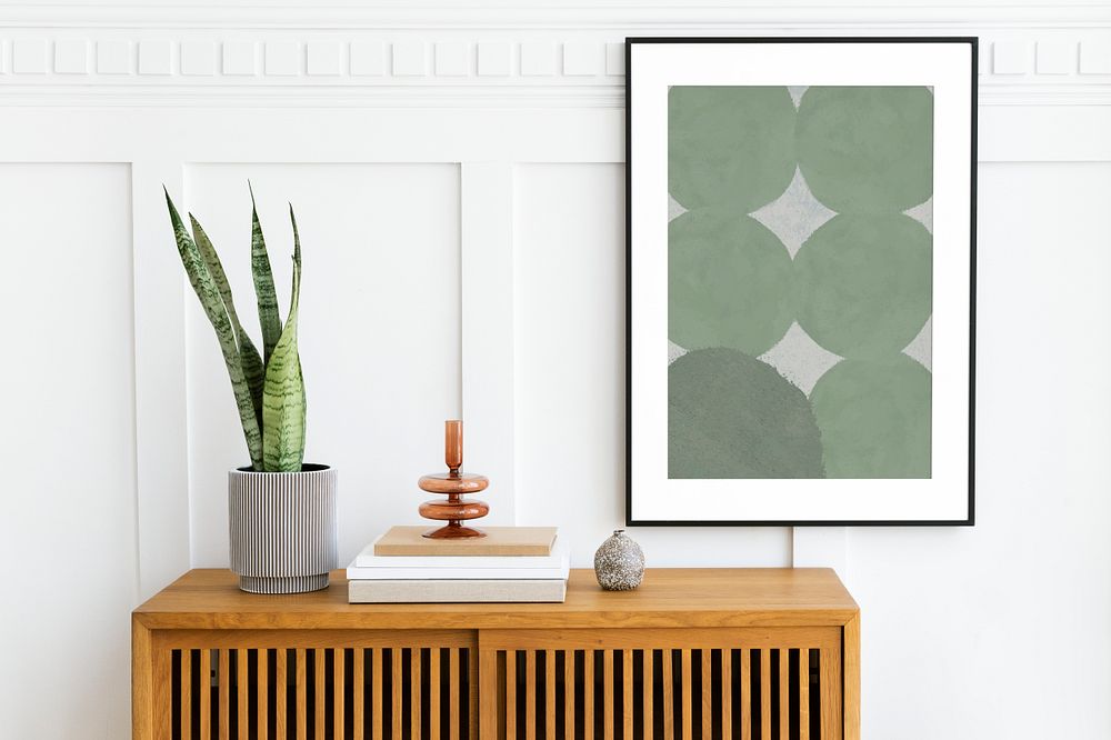 Picture frame mockup hanging above a wooden cabinet