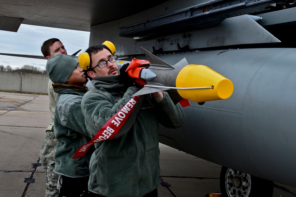 U.S. Airmen with a weapons load crew with the 48th Air Expeditionary Group mount an AIM-9X Sidewinder missile onto an F-15C…