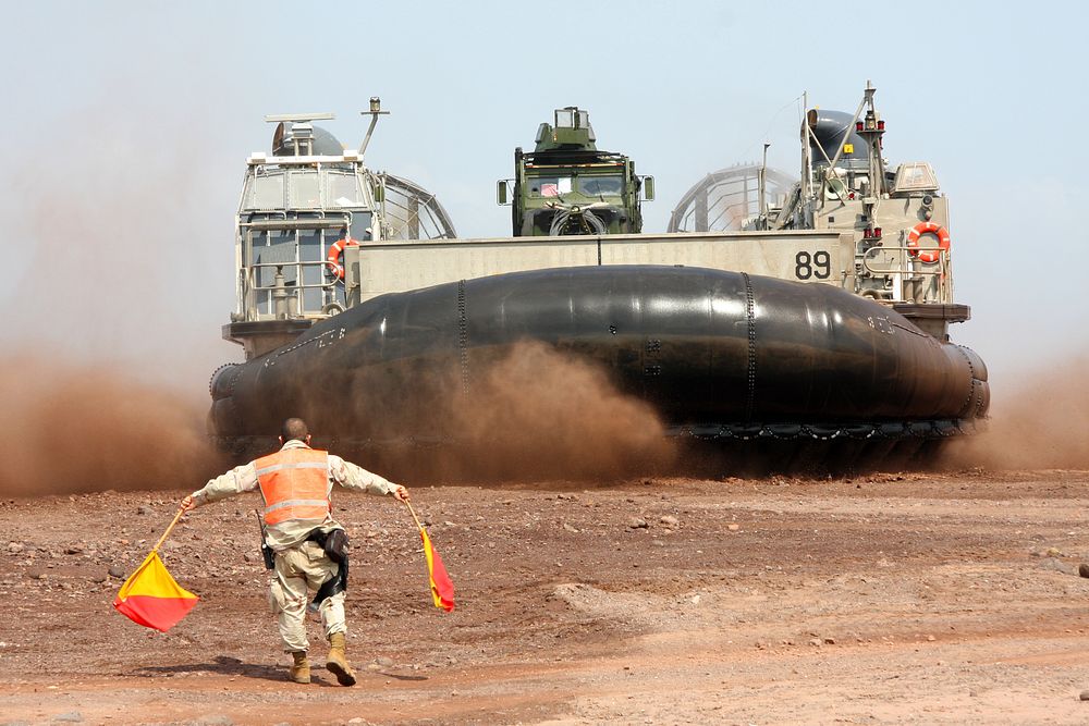 A U.S. service member directs a landing craft, air cushion carrying Marines and equipment onto the beach in Djibouti March…