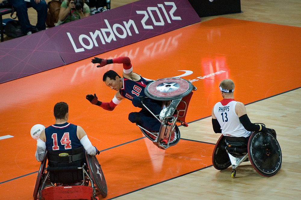 Retired U.S. Sailor William Groulx, center, the U.S. wheelchair rugby team captain, takes a spill after a crash with a Great…