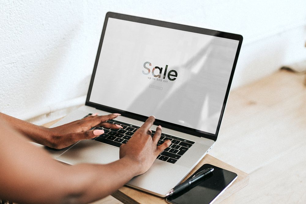 Black woman using a laptop on a wooden table