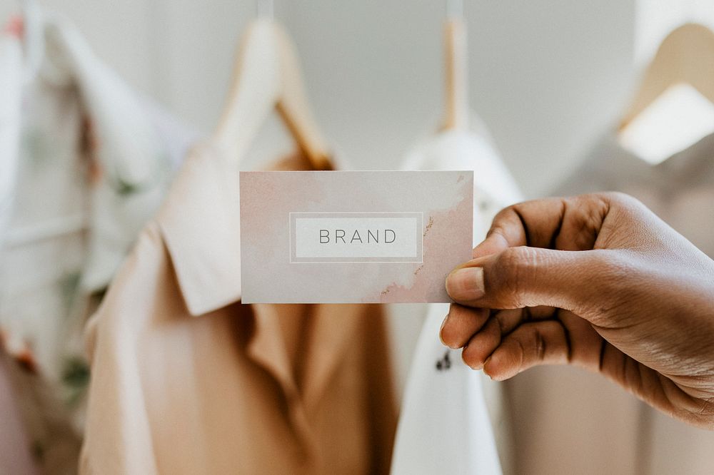 Hand holding business card at a boutique