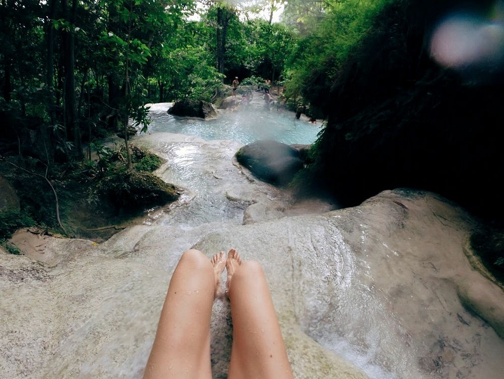 Girl sitting in a waterfall