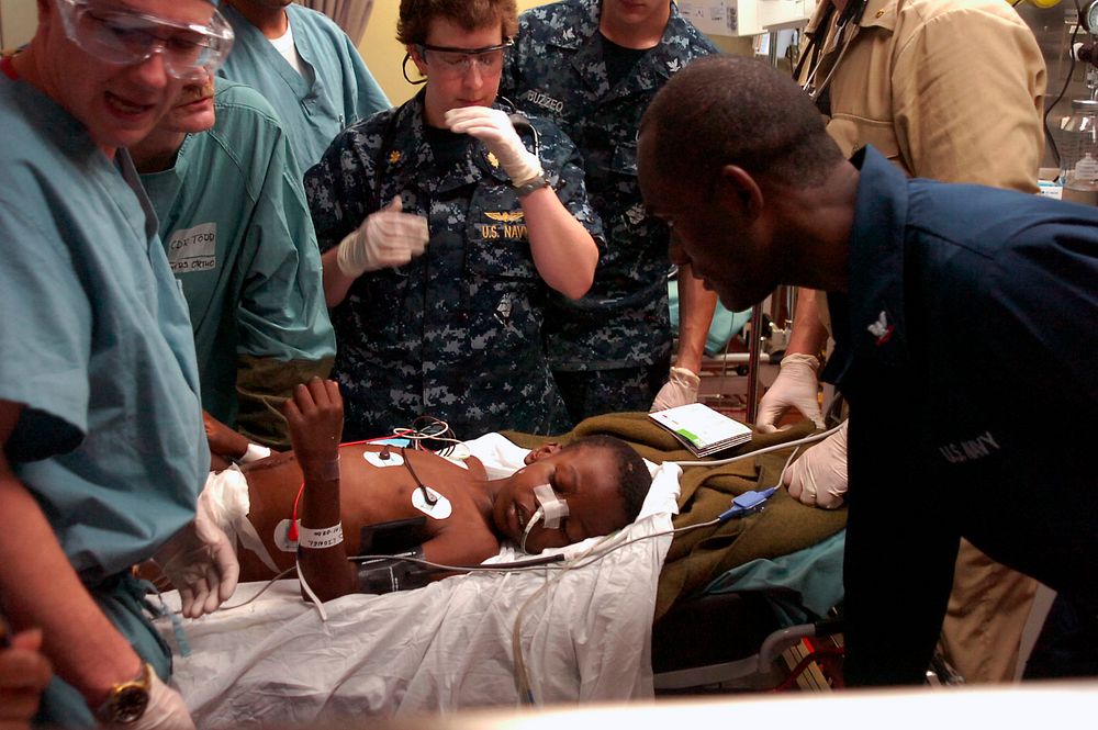 Medical personnel aboard the Military Sealift Command hospital ship USNS Comfort (T-AH 20) treat a Haitian boy in the…