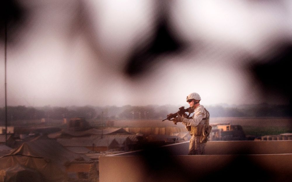Marine hold security over Afghan village from roof top