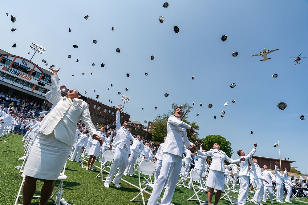 Cadets toss their caps during a Coast Guard flyover at the conclusion of the Coast Guard Academy Commencement on Wednesday…