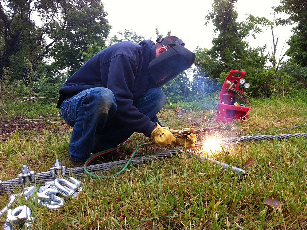 Anchoring the log boom at Roush LakeHuntington, Ind. &mdash; DJ Unger uses a cutting torch to cut a cable used in anchoring…