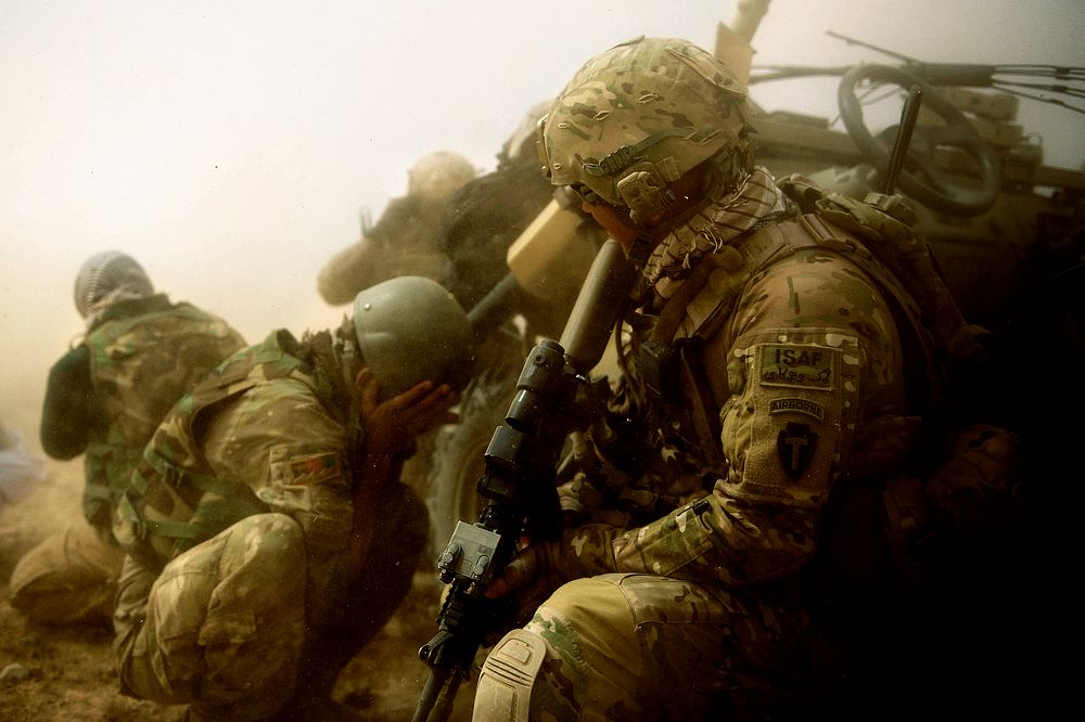 U.S. Army Staff Sgt. James Bates, with Provincial Reconstruction Team Farah, attempts to avoid flying debris kicked up by a…