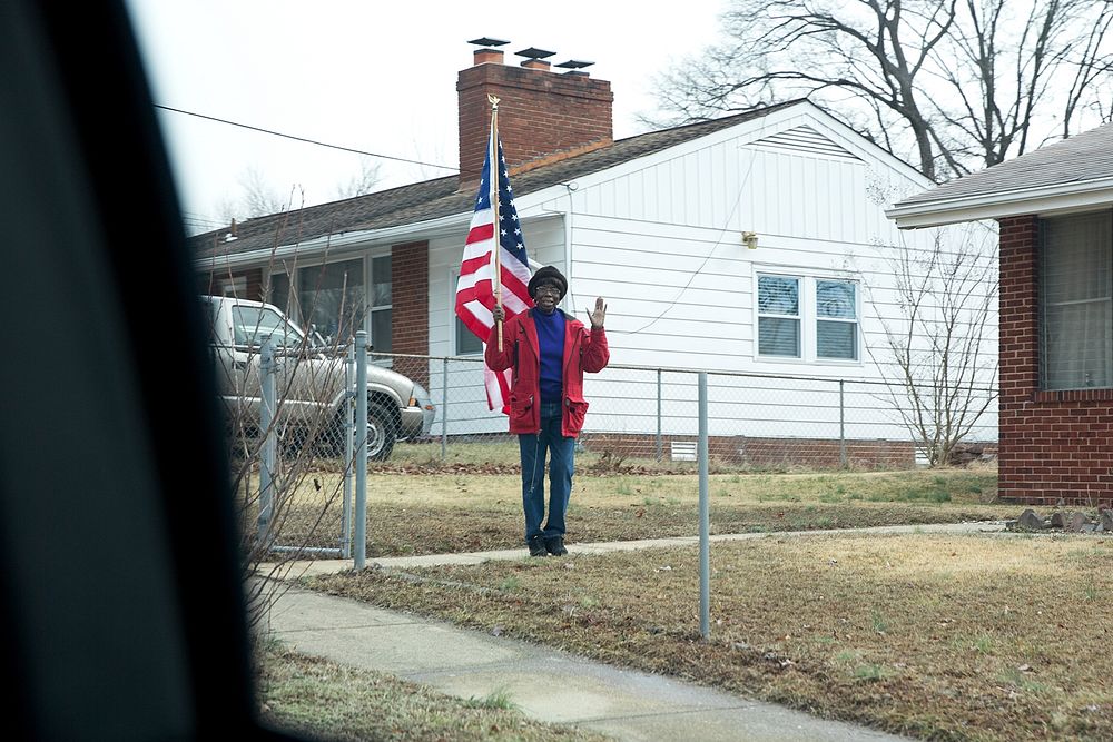 A local resident waves as President Barack Obama travels by motorcade en route to Buck Lodge Middle School in Adelphi, Md.…