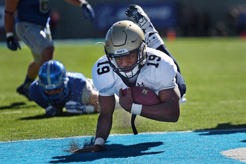 Navy quarterback Keenan Reynolds lands in the end zone for a touchdown against Air Force at the Air Force Academy in…