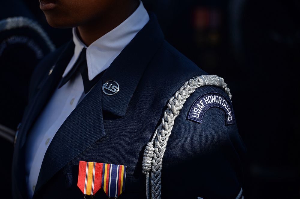 A sunray illuminates a uniform belonging to an airman in the Air Force Honor Guard during a wreath-laying ceremony at the…