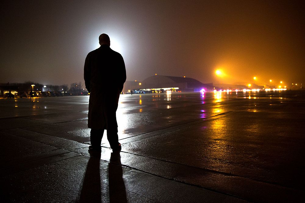 A Secret Service agent stands on the tarmac waiting for President Barack Obama and First Lady Michelle Obama to arrive by…