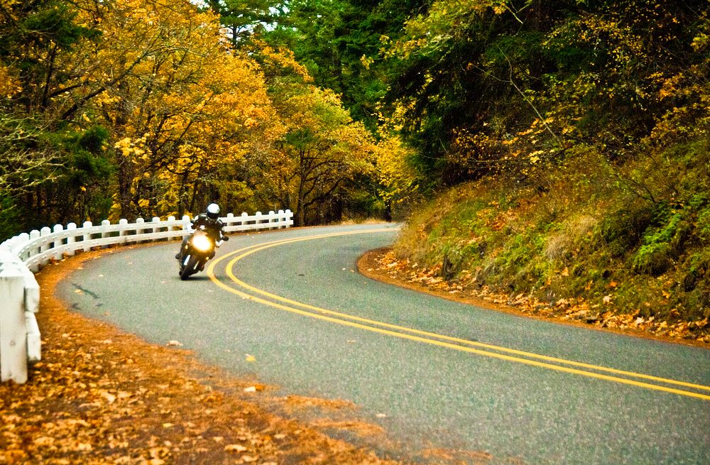 MOTORCYCLIST ON 30_COLUMBIA RIVER GORGEMotorcyclist driving along Highway 30 in Oregon during autumn-Columbia River Gorge…