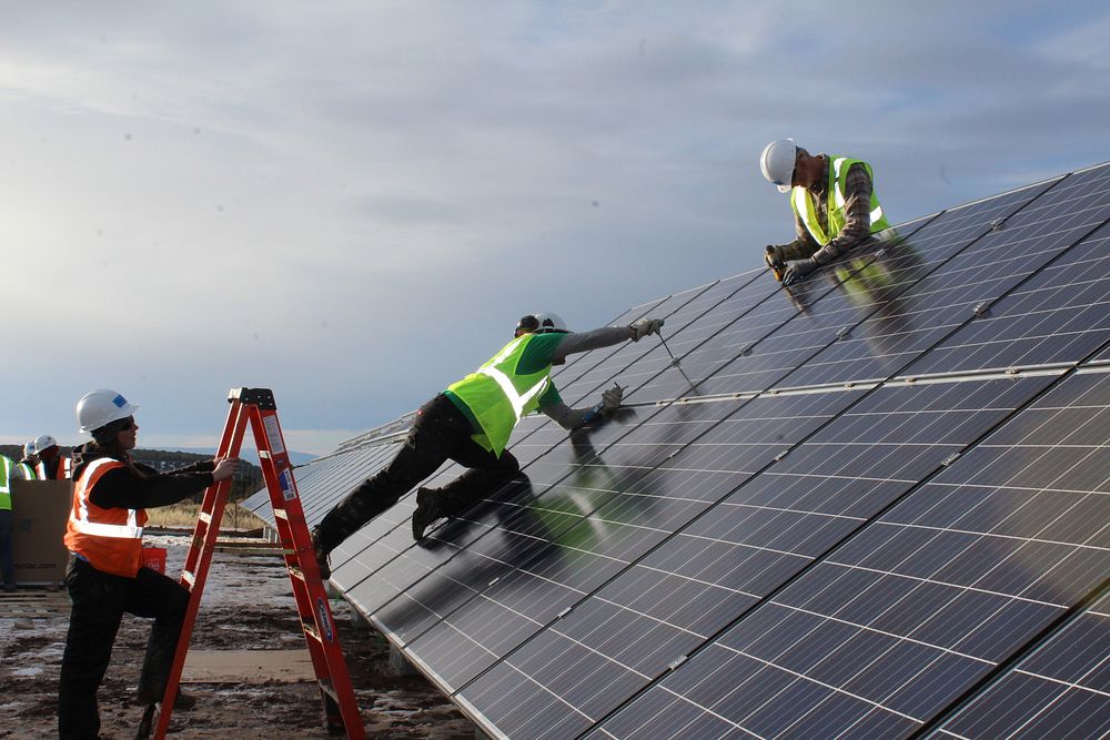 GRID Alternatives solar installers and volunteers work to construct a community solar array in Norwood, Colorado. Original…