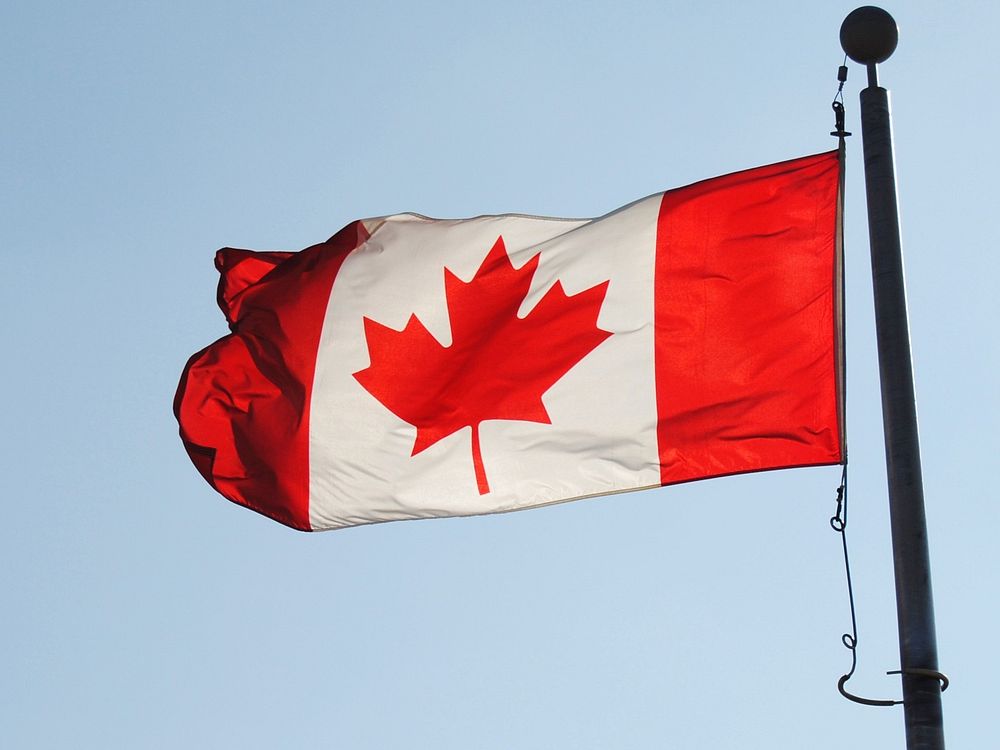 Canadian flag against blue sky. Free public domain CC0 photo.