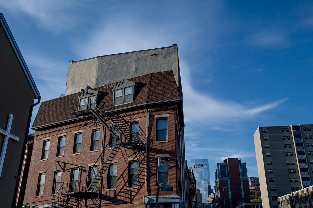 Low angle view of buildings with emergency exit stairs and blue sky in New York City