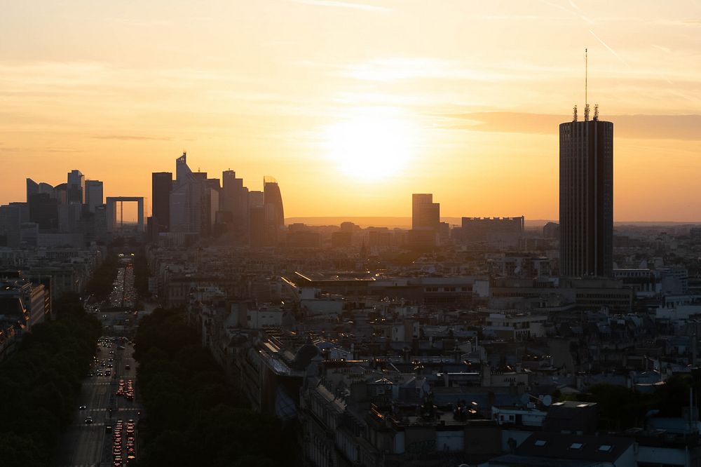 Aerial view of skyscrapers of Paris with cars on roads during sunset