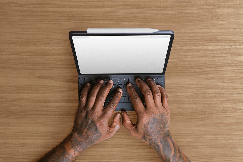 Tattooed man using tablet keyboard