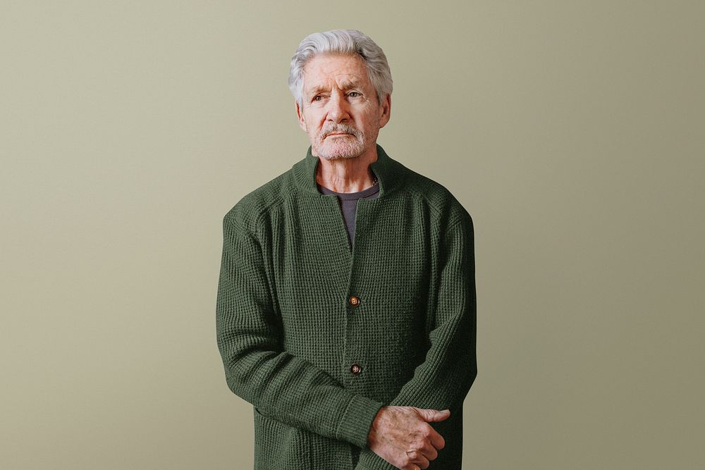 Senior man in cardigan, isolated on green