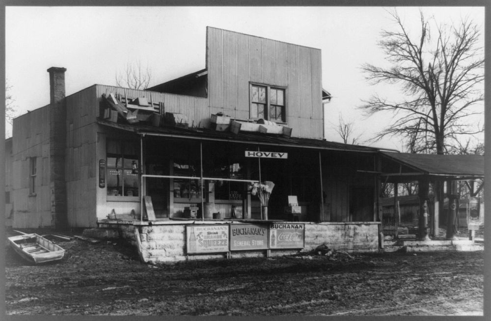 Buchanan's general store at Hovey, Indiana, open for business after the flood. Note furniture placed on roof to protect it…