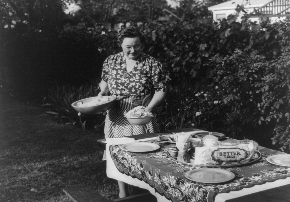 Turlock, California. Housewife serves dinner in the backyard of her home. Menu: barbecued steaks, fresh peas, potato salad…
