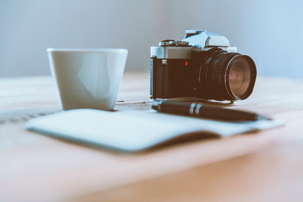 Creative desk with camera and notebook